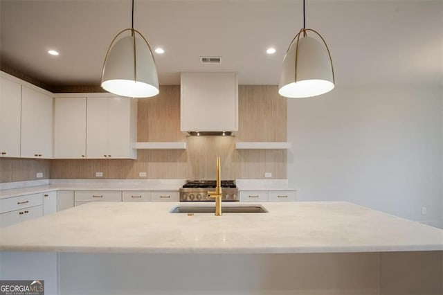 310 Arbor Garden Cir, Newnan, GA 30265 - kitchen featuring a sink, light stone countertops, decorative backsplash, a kitchen island with sink, and recessed lighting