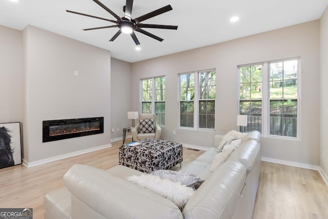 6960 Dockbridge Way, Stone Mountain, GA 30087 - living room featuring a ceiling fan, light wood-type flooring, a glass covered fireplace, and recessed lighting