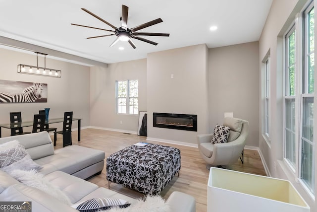 6960 Dockbridge Way, Stone Mountain, GA 30087 - living area featuring light wood finished floors, recessed lighting, a ceiling fan, and a glass covered fireplace