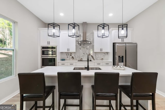 6960 Dockbridge Way, Stone Mountain, GA 30087 - kitchen with stainless steel appliances, wall chimney exhaust hood, decorative backsplash, light countertops, and white cabinetry