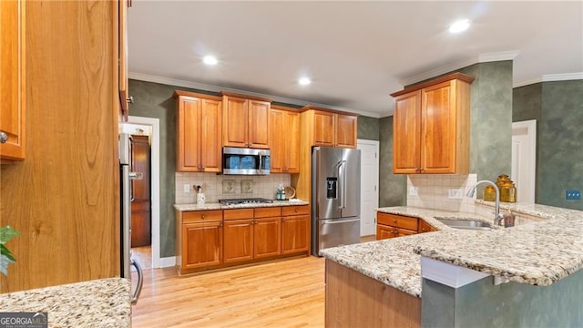104 Kremer Falls Trce, Canton, GA 30114 - kitchen featuring appliances with stainless steel finishes, a sink, a peninsula, light wood finished floors, and light stone counters