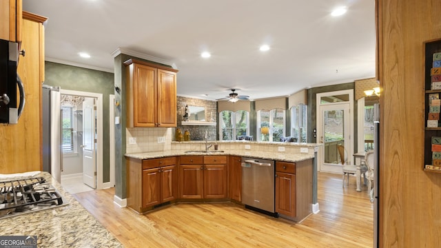 kitchen with brown cabinets, ceiling fan, a peninsula, and stainless steel appliances