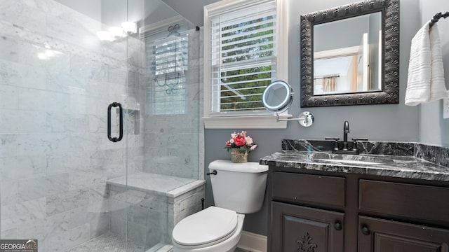 bathroom featuring toilet, a stall shower, and vanity