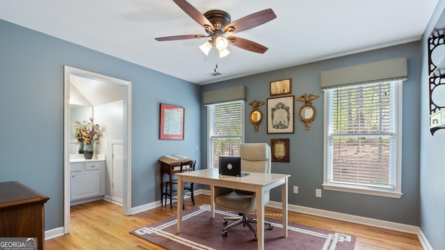 office featuring light wood-type flooring, ceiling fan, baseboards, and visible vents
