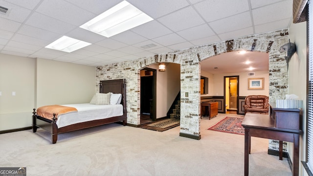 bedroom with arched walkways, carpet flooring, a paneled ceiling, and visible vents