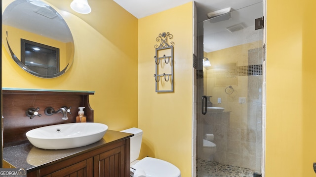 bathroom with visible vents, toilet, a shower stall, and vanity
