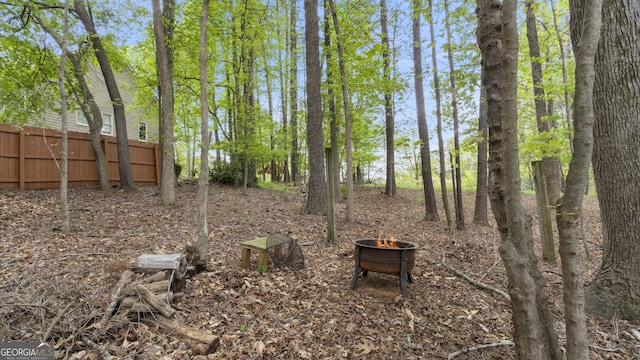 view of yard with a fire pit and fence