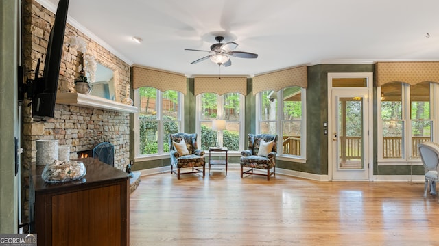 sunroom featuring baseboards, ornamental molding, and wood finished floors