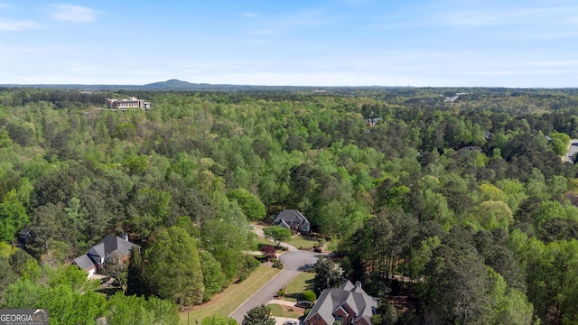 bird's eye view with a wooded view