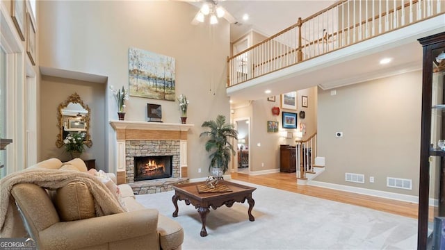 104 Kremer Falls Trce, Canton, GA 30114 - living room with a towering ceiling, stairs, a fireplace, ceiling fan, and wood finished floors