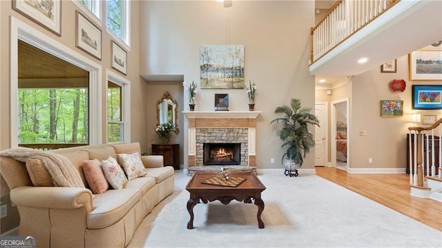 104 Kremer Falls Trce, Canton, GA 30114 - living room featuring a towering ceiling, healthy amount of natural light, a stone fireplace, wood finished floors, and baseboards