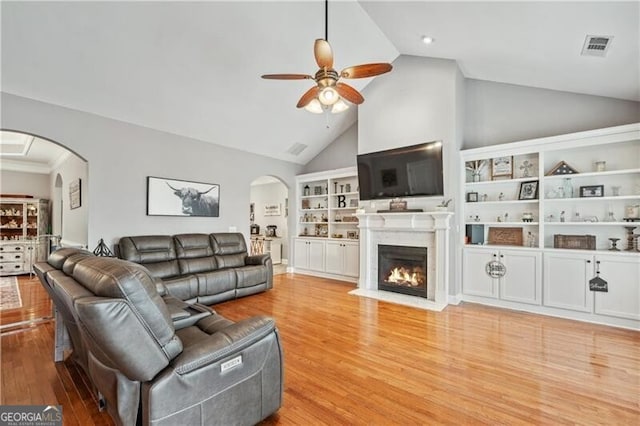 698 Jefferson Hwy, Winder, GA 30680 - living area with arched walkways, ceiling fan, wood finished floors, a fireplace with flush hearth, and high vaulted ceiling