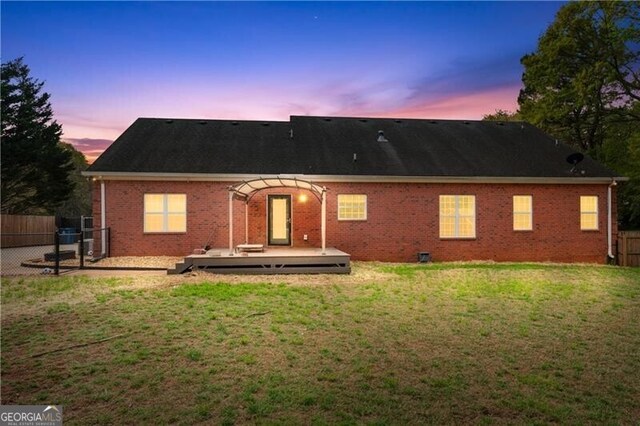 698 Jefferson Hwy, Winder, GA 30680 - back of house at dusk featuring a deck and brick siding