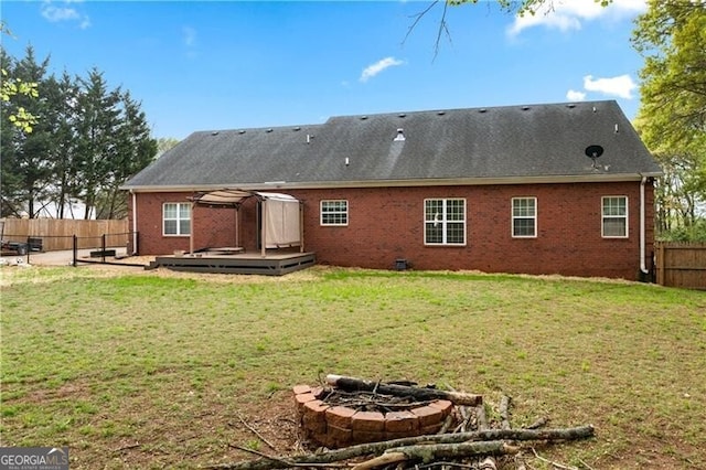 698 Jefferson Hwy, Winder, GA 30680 - rear view of property featuring a fenced backyard, an outdoor fire pit, a deck, and brick siding