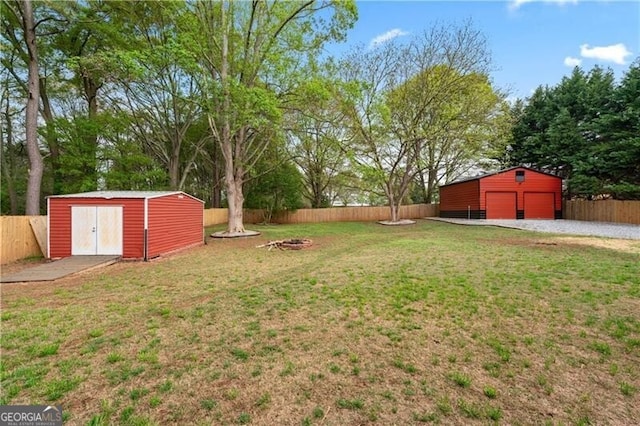 698 Jefferson Hwy, Winder, GA 30680 - fenced backyard with an outbuilding, a fire pit, and a detached garage