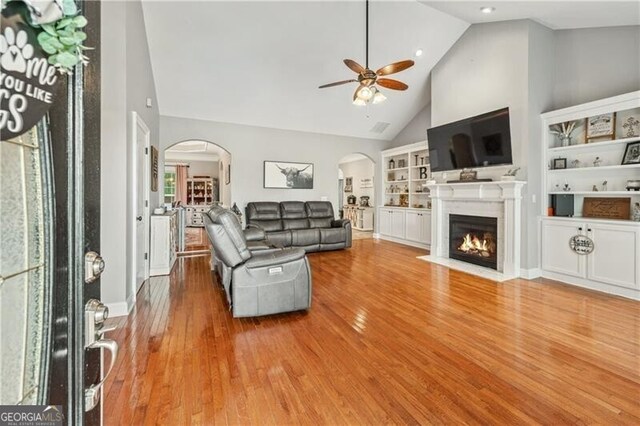 698 Jefferson Hwy, Winder, GA 30680 - living room with arched walkways, ceiling fan, high vaulted ceiling, a fireplace with flush hearth, and wood finished floors
