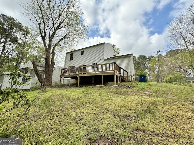 back of property featuring an outbuilding, a lawn, a deck, and a shed