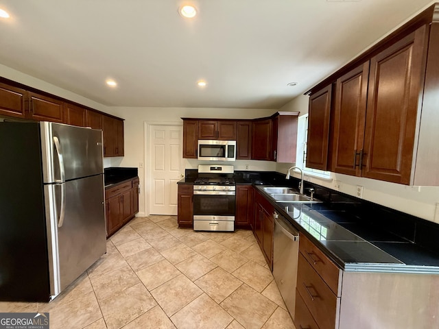 kitchen featuring recessed lighting, dark brown cabinets, dark countertops, stainless steel appliances, and a sink