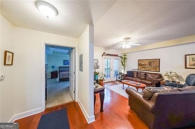 living room with baseboards, electric panel, french doors, a ceiling fan, and wood finished floors
