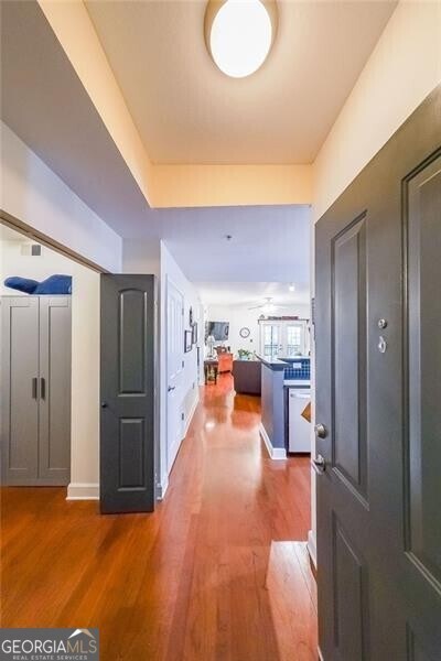 corridor with baseboards and wood finished floors
