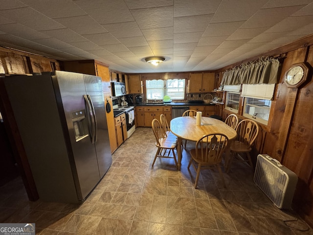 kitchen featuring brown cabinetry, dark countertops, and stainless steel appliances