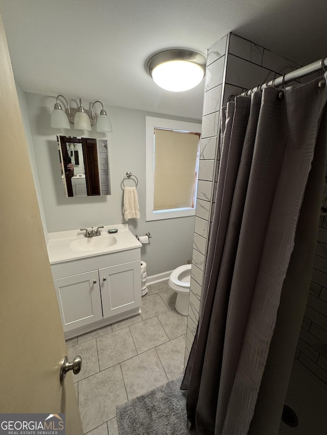 bathroom featuring baseboards, a shower with shower curtain, toilet, vanity, and tile patterned floors