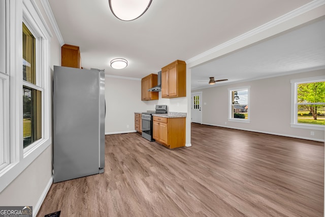kitchen featuring wall chimney exhaust hood, light wood-type flooring, ornamental molding, and appliances with stainless steel finishes