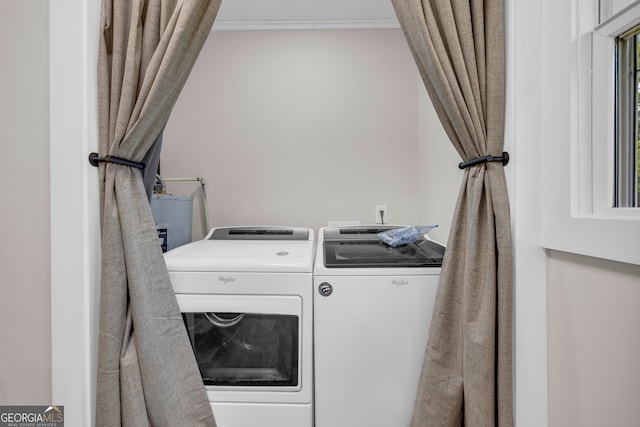 laundry room featuring laundry area, crown molding, washing machine and clothes dryer, and a sink