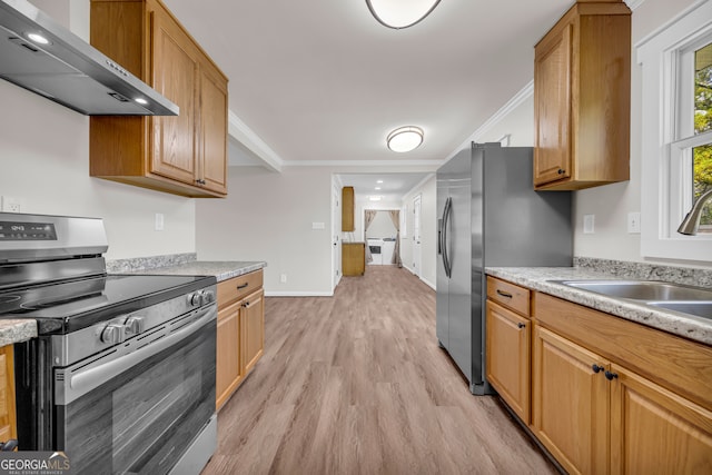 kitchen featuring crown molding, appliances with stainless steel finishes, a sink, and wall chimney exhaust hood