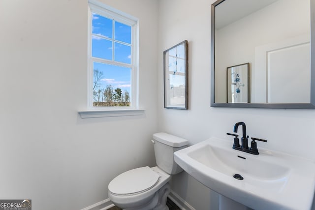 bathroom featuring a sink, toilet, and baseboards