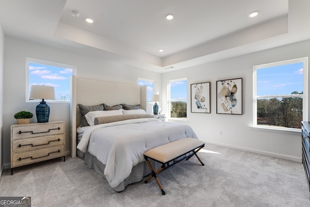 bedroom with baseboards, light carpet, recessed lighting, visible vents, and a raised ceiling