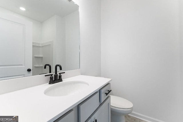 bathroom with vanity, baseboards, and toilet