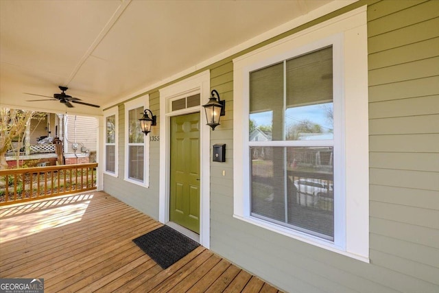 wooden terrace with a porch and ceiling fan