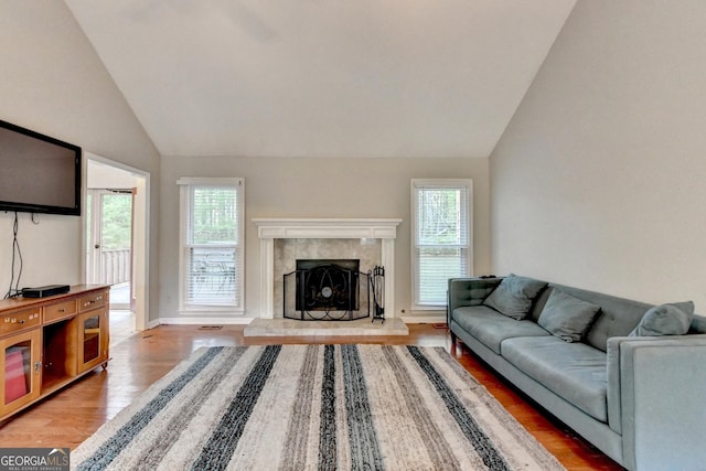 6040 Carriage Dr, Cumming, GA 30028 - living room featuring a fireplace, light wood-style flooring, baseboards, and vaulted ceiling