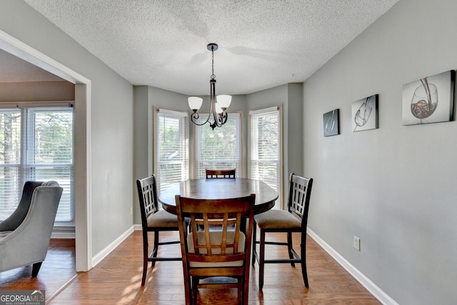 6040 Carriage Dr, Cumming, GA 30028 - dining room featuring visible vents, light wood-type flooring, an inviting chandelier, and a textured ceiling