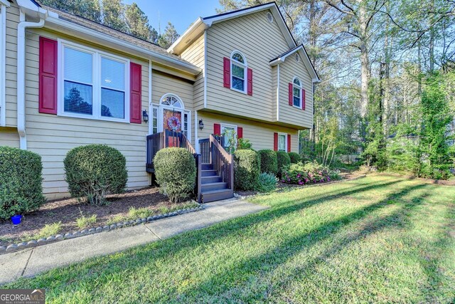 6040 Carriage Dr, Cumming, GA 30028 - tri-level home featuring a front yard and a shingled roof