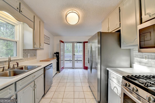 6040 Carriage Dr, Cumming, GA 30028 - kitchen featuring appliances with stainless steel finishes, light countertops, a sink, french doors, and plenty of natural light