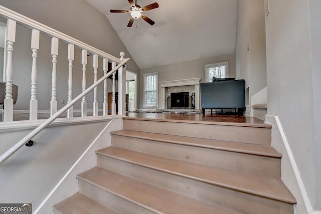 6040 Carriage Dr, Cumming, GA 30028 - staircase with ceiling fan, lofted ceiling, a fireplace, and a healthy amount of sunlight