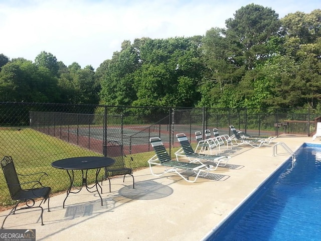 6040 Carriage Dr, Cumming, GA 30028 - community pool featuring a patio, fence, and a lawn