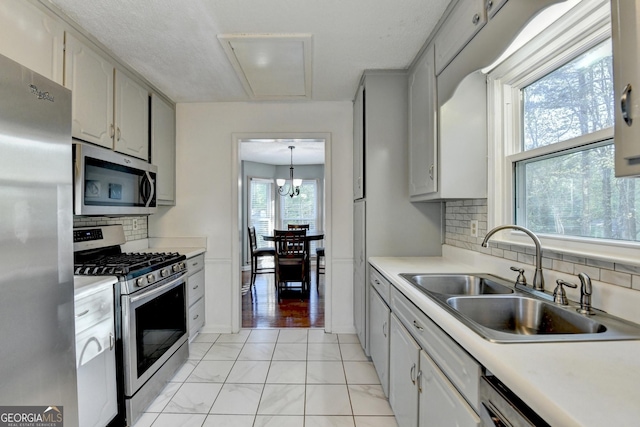6040 Carriage Dr, Cumming, GA 30028 - kitchen with appliances with stainless steel finishes, baseboards, light countertops, decorative backsplash, and a sink