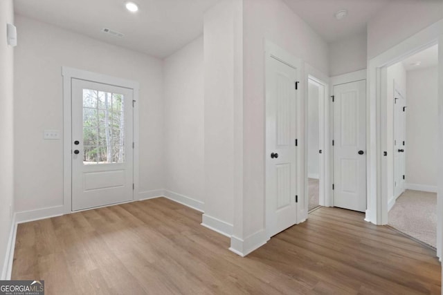 foyer featuring recessed lighting, light wood-style flooring, baseboards, and visible vents