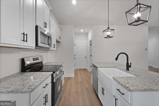 kitchen with light wood-style floors, white cabinets, appliances with stainless steel finishes, and recessed lighting
