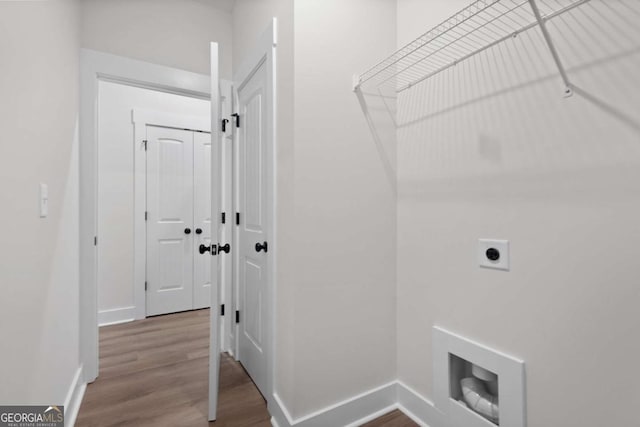 laundry area with baseboards, hookup for an electric dryer, wood finished floors, and laundry area