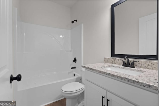 full bath featuring toilet, wood finished floors, vanity, and  shower combination