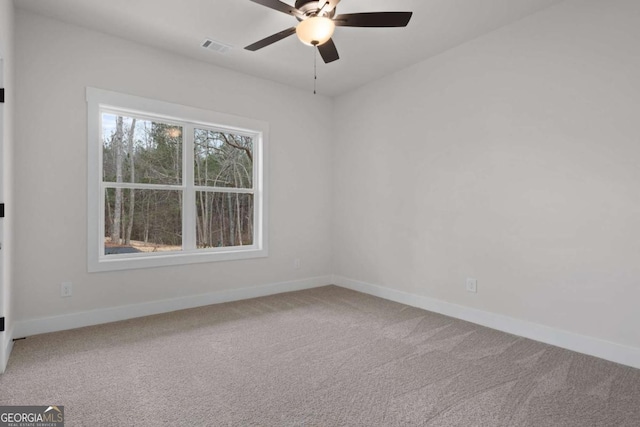 empty room featuring carpet floors, baseboards, a ceiling fan, and visible vents