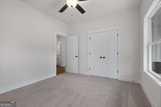 unfurnished bedroom with a closet, baseboards, carpet flooring, and ceiling fan