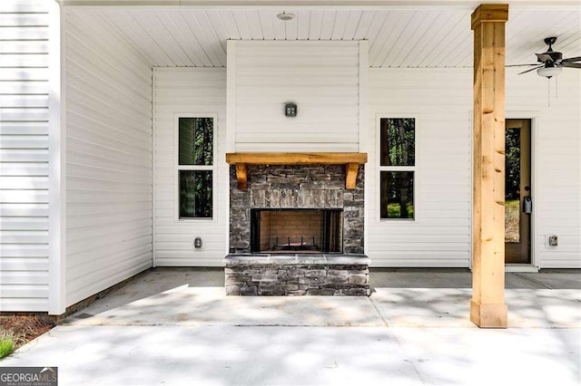 view of patio / terrace with ceiling fan and an outdoor stone fireplace