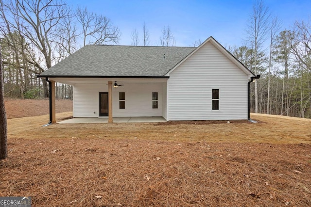 back of property with roof with shingles, a patio area, and a ceiling fan