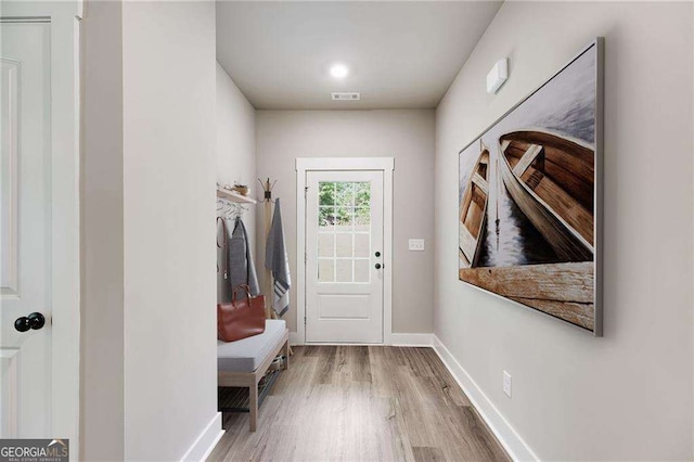 mudroom featuring visible vents, baseboards, and wood finished floors