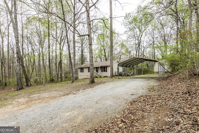 view of front of home with a detached carport and dirt driveway